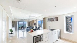 A modern kitchen with a central island, a built-in microwave, and a dishwasher.
