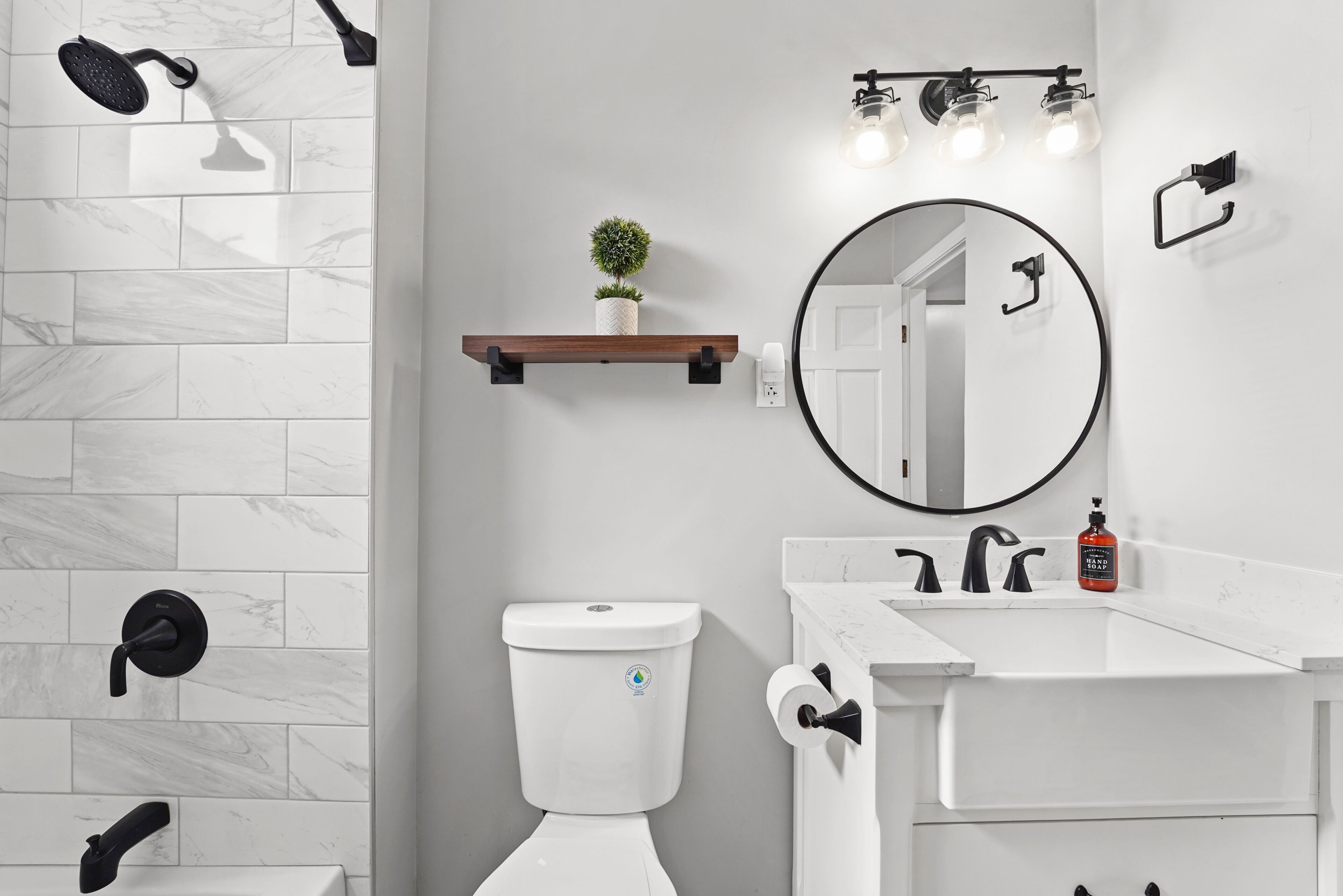 Un baño moderno con inodoro, lavamanos y ducha.