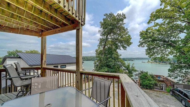 A deck with outdoor seating and a view of a lake.
