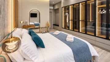A modern bedroom with a large bed, bedside tables, a mirror, and a wardrobe with illuminated sections.