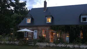 Et murstenshus med skråt tag, to små vinduer og en dør.