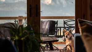 Ein gemütliches Zimmer mit Bergblick, einem Hund und Möbeln.