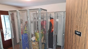 Une pièce contenant des cages en métal séparées par des cloisons, chacune étant munie d’une étiquette indiquant un numéro.