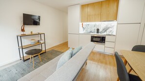 Una cocina moderna con armarios de madera, horno empotrado y ventana sobre el fregadero.