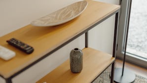 A wooden table with a white plate and a remote control. - Courtyard Oporto Design Apartment L With Terrace (Porto)