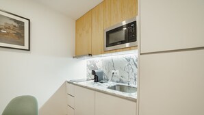 A compact kitchen with a microwave, a coffee maker, and a sink. - Courtyard Oporto Design Apartment L With Terrace (Porto)