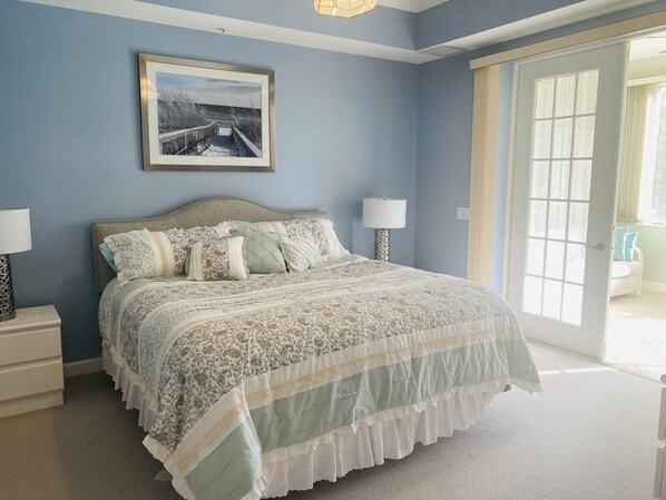 A bedroom with a bed, two bedside tables, a lamp, a framed picture on the wall, and a door leading to another room. - An enchanting site, close to everything (Naples)