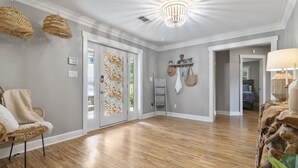 A spacious room with hardwood flooring, a chandelier, wicker hanging lights, and a door with a mosaic design. - Lake Hamilton Waterfront Home Dock, Firepit, Sleeps 12 (Hot Springs)