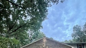 A rustic brick building with large windows, a wooden staircase, and outdoor lighting. - Lake Hamilton Waterfront Home Dock, Firepit, Sleeps 12 (Hot Springs)