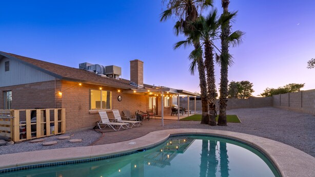 Una propiedad residencial con piscina, zona de estar al aire libre y patio.