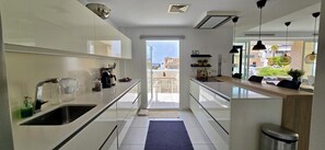 Una cucina moderna con vista sull'esterno, un'area pranzo e un piccolo balcone.
