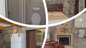 A compact kitchen with a stone wall, a wooden dining table, and a built-in fireplace. - Koilada Konaklari (Gökçeada)