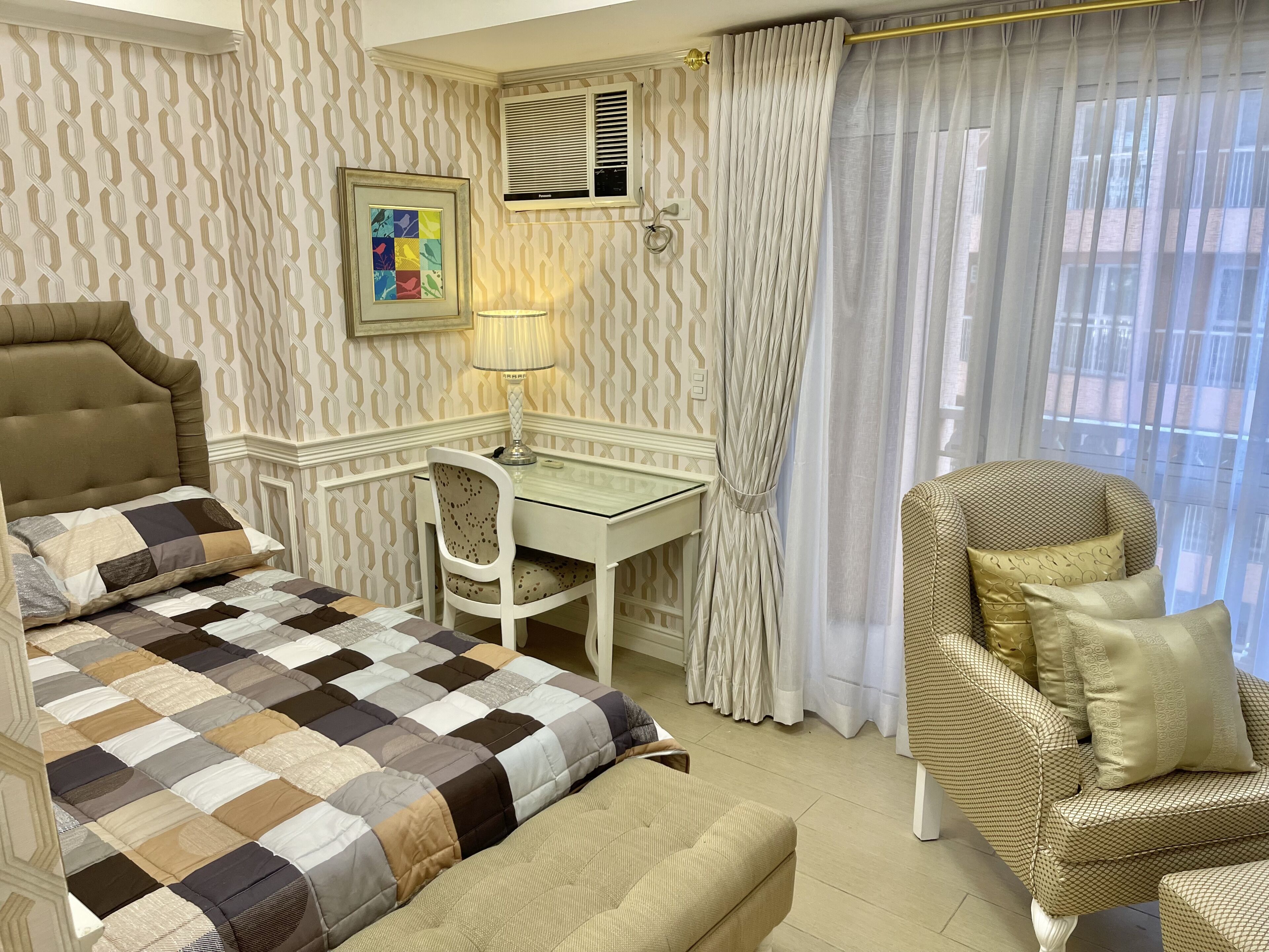 A neatly arranged bedroom with a bed, desk, and two chairs.