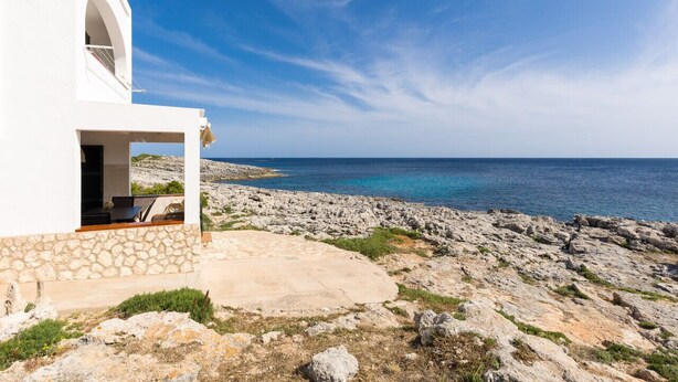 A coastal building with a stone facade and a view of the sea. - Binilaya - Charming 3-bedroom house - seafront (Binibèquer Nou)