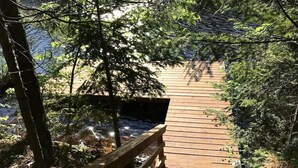 Un ponte di legno in una zona boschiva, con un ruscello sotto.