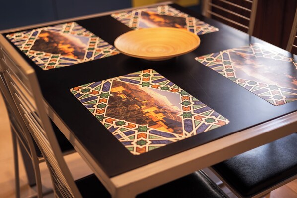 A table with a wooden bowl and a patterned placemat.
