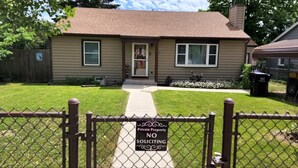 A two-story house with a front yard, a 'No Soliciting' sign, and a chain-link fence.