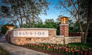 A stone wall with a sign reading 'BAYSIDE' and a brick tower with lights.
