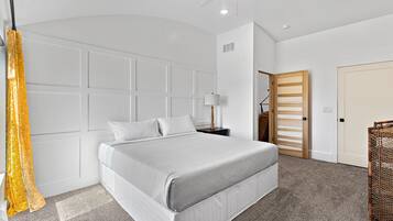 A modern bedroom with a bed, a nightstand, a lamp, and a wardrobe.