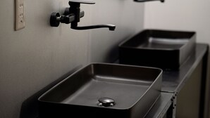 A bathroom with a single sink and a faucet.