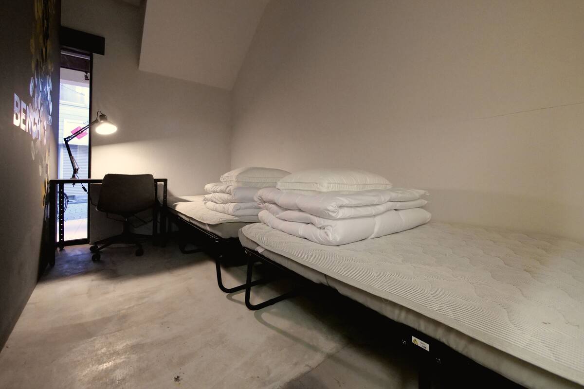 A room with a bunk bed, a desk, and a chair.