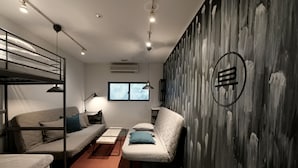 A compact room with bunk beds, a sofa, a desk, and a chair.