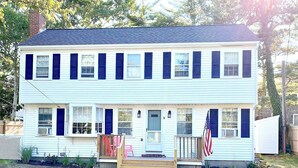 A two-story house with a front porch, a mailbox, and an American flag. - Short 1/2 mile walk to the beach! Located in beautiful Harwich. (Harwich)