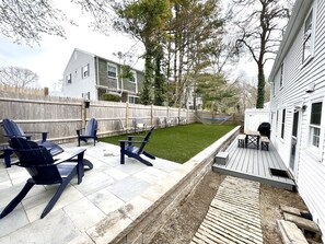 A backyard with a wooden deck, outdoor seating, a hammock, and a grill area. - Short 1/2 mile walk to the beach! Located in beautiful Harwich. (Harwich)