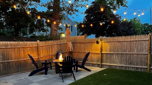 A backyard patio with a fire pit, outdoor furniture, and string lights. - Short 1/2 mile walk to the beach! Located in beautiful Harwich. (Harwich)