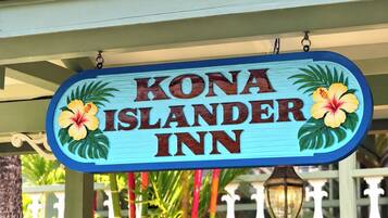 Señal para Kona Islander Inn con decoraciones florales tropicales.