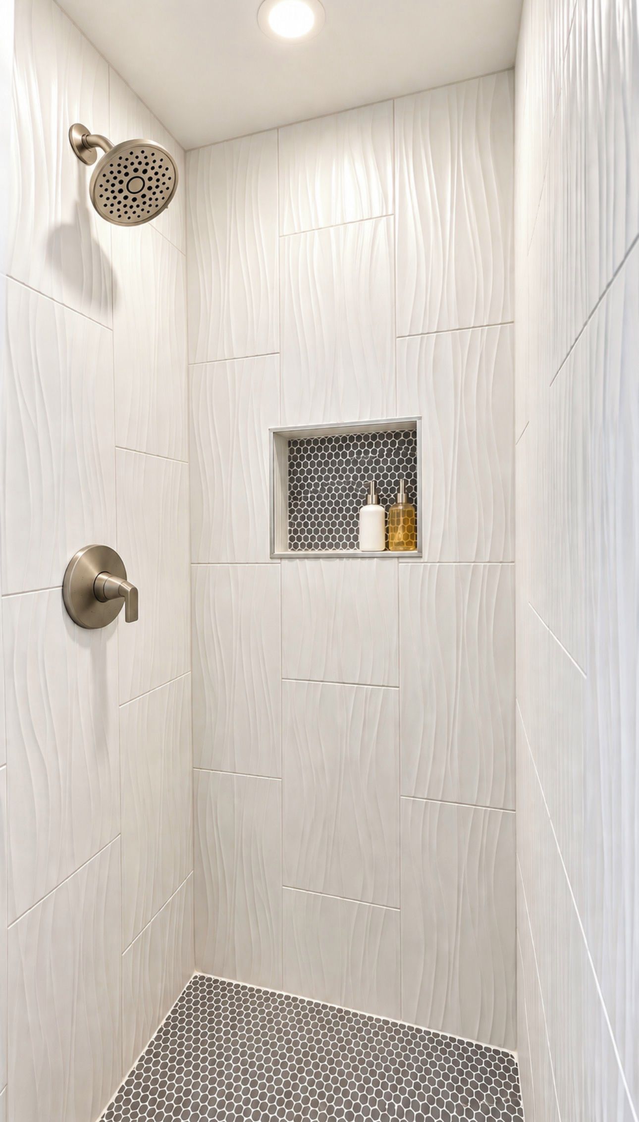 A shower with a rain showerhead, a wall-mounted soap dispenser, and a small shelf with two bottles.