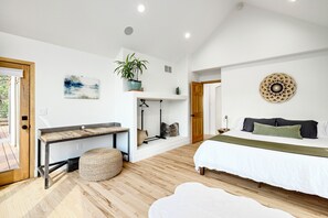 A bedroom with a bed, bedside table, and a hanging plant. - 6BR Mountain Retreat • Hot Tub • Walk to Pearl St (Boulder)