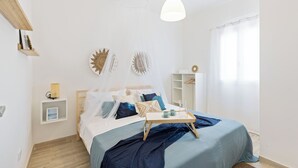 A neatly arranged bedroom with a bed, bedside tables, a bedside lamp, and a window with curtains. - Tocco di Blu  SicilyMyHome (Santa Maria del Focallo)