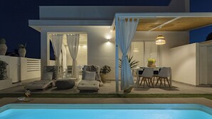 A modern outdoor pool area with lounge chairs and a dining table. - Tocco di Blu  SicilyMyHome (Santa Maria del Focallo)
