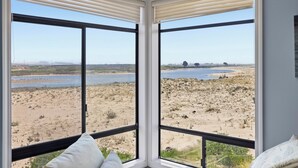 A room with large windows offering a view of a beach and water. - Pelican 54: Relax with an ocean view. (Pajaro Dunes)