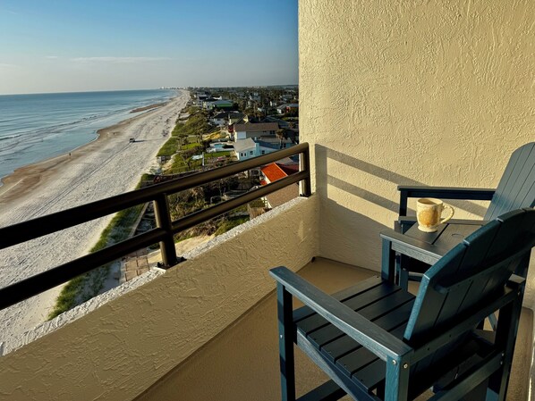 A balcony with a view of a beach and houses. - Beachview Oasis - NO DRIVE BEACH - Amazing Amenities! CONSTRUCTION IS OVER! (Daytona Beach)