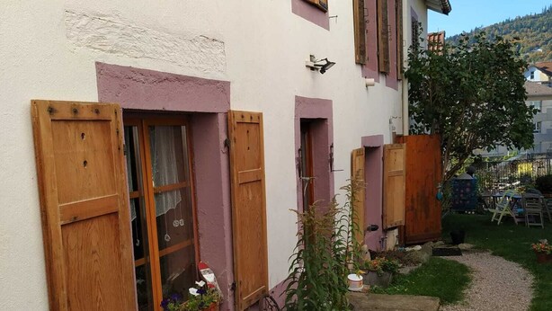 A house with wooden shutters, a gravel path, and flower beds. - ALL WOODEN APARTMENT WITH GARDEN 100 meters from town center in quiet location. (Gérardmer)