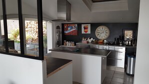 Eine moderne Küche mit großem Fenster, Edelstahlgeräten und Bildern an der Wand.