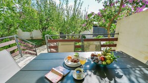 Een tafel met een boek, een glas sap en een schaal vol fruit.