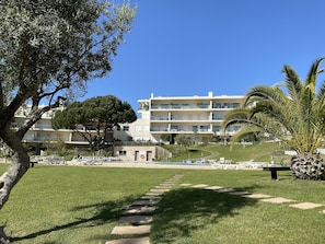 Um hotel com piscina, área de estar externa e gramado bem cuidado.