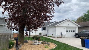 A residential house with a front yard, mailbox, and a parked car.