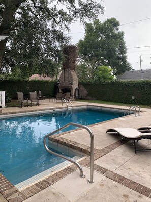 A swimming pool with a brick wall and a stone fireplace in the background. - Private oasis, fully furnished, ready to move in. Luxury finishes.  6beds 7baths (Biloxi)