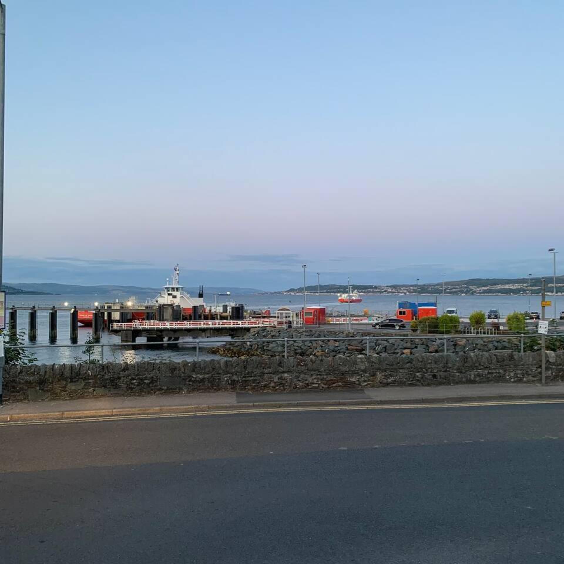 Un puerto con muelle, un barco y un puente.