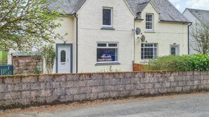 A two-story house with a gabled roof, a front door, and a small window. - Craik Forestry Cottage (Craik, near Hawick)