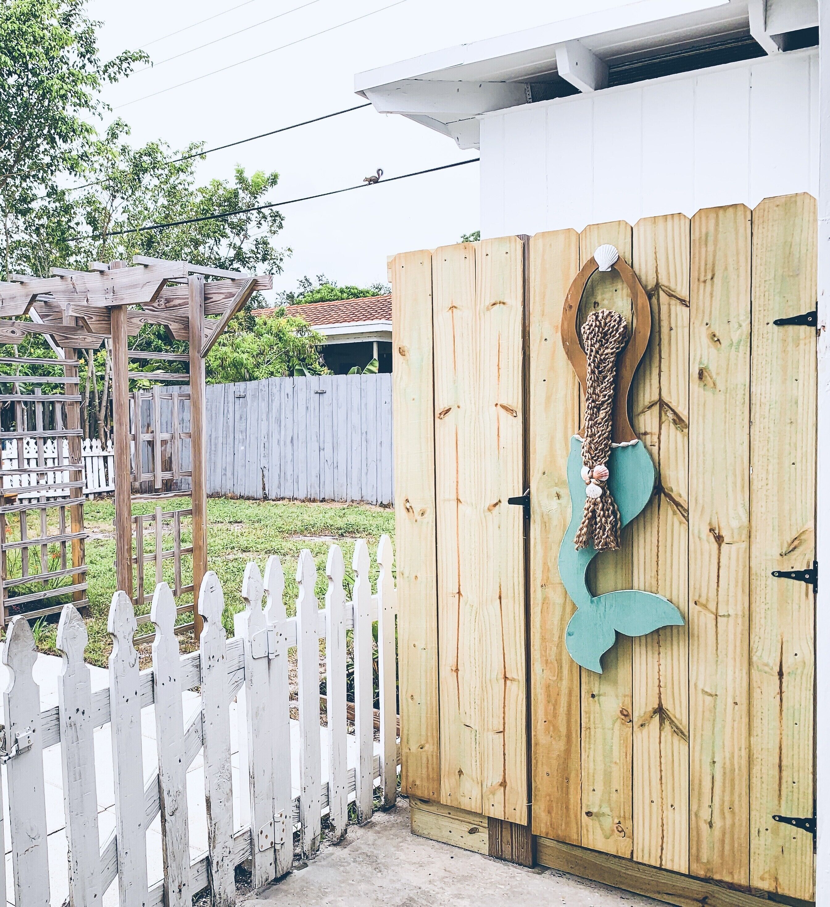 Une porte en bois ornée d’une queue de sirène décorative qui y est suspendue.