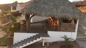Una estructura con techo de paja y una escalera que conduce a una zona de bar.