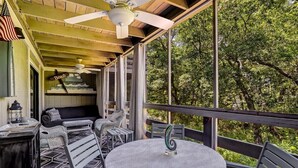A covered outdoor seating area with a round table, chairs, and a ceiling fan. - Central Oasis: Pool, Tennis, Screened Porch Gem! (Fernandina Beach)