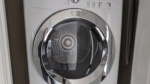 A stacked washer and dryer unit in a laundry room.