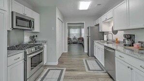 A modern kitchen with white cabinets, stainless steel appliances, and a central island. - CHAS, SUMMRVLL/NEXTON Comfort  Near Everything! (Summerville)