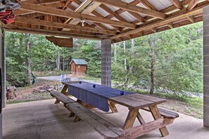 A covered picnic table with benches, set against a forest backdrop. - Cabins at Brush Creek Mtn-Bear Den (Del Rio)